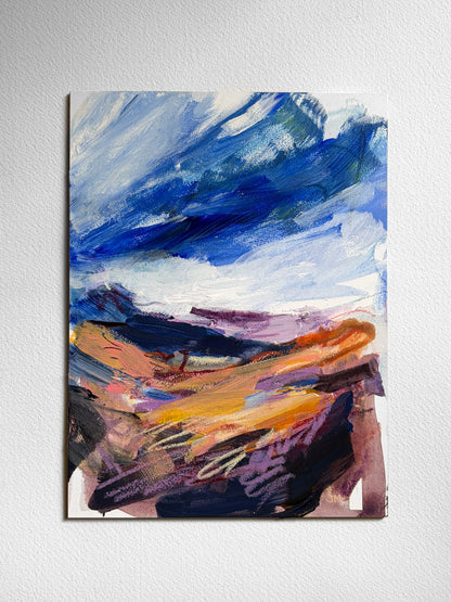 An abstract landscape painting on board, featuring textured brushstrokes of blue, white, orange, purple, and black, displayed on a light gray textured wall.