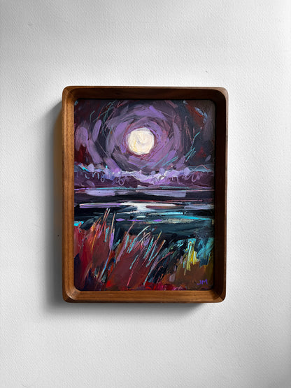 A framed painting of a moonlit landscape with swirling violet sky, dark water, and red-and-teal grasses, displayed on a light gray wall.