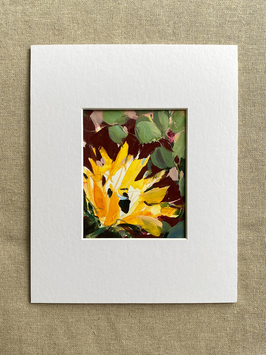 Matted artwork of a yellow sunflower with green leaves on a textured beige background