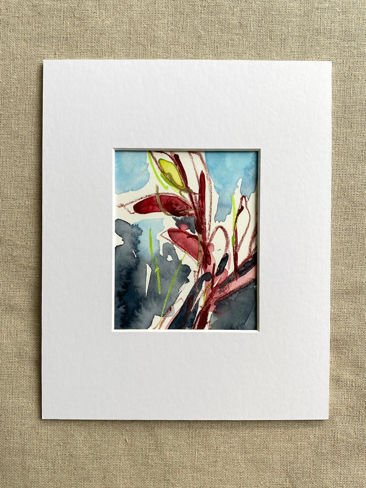 Painting of a red and green plant in a white mat on a textured beige background