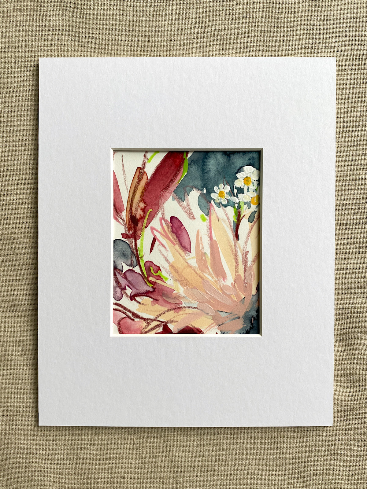 Floral watercolor painting in a white mat on a textured beige background
