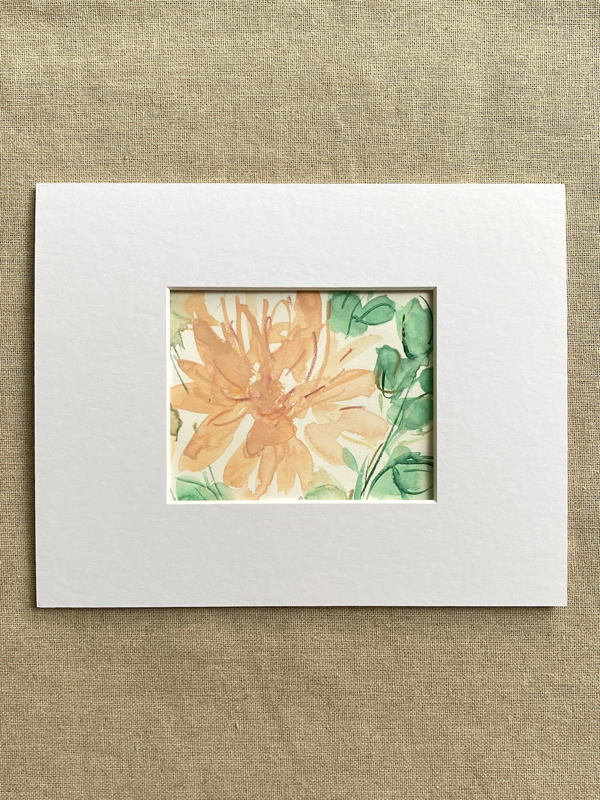 Peach and green floral painting  in a white mat on beige textured background