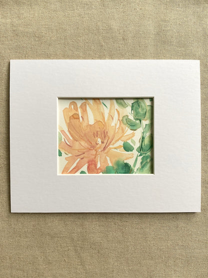 Matted artwork of a peach and green floral design on a textured beige background